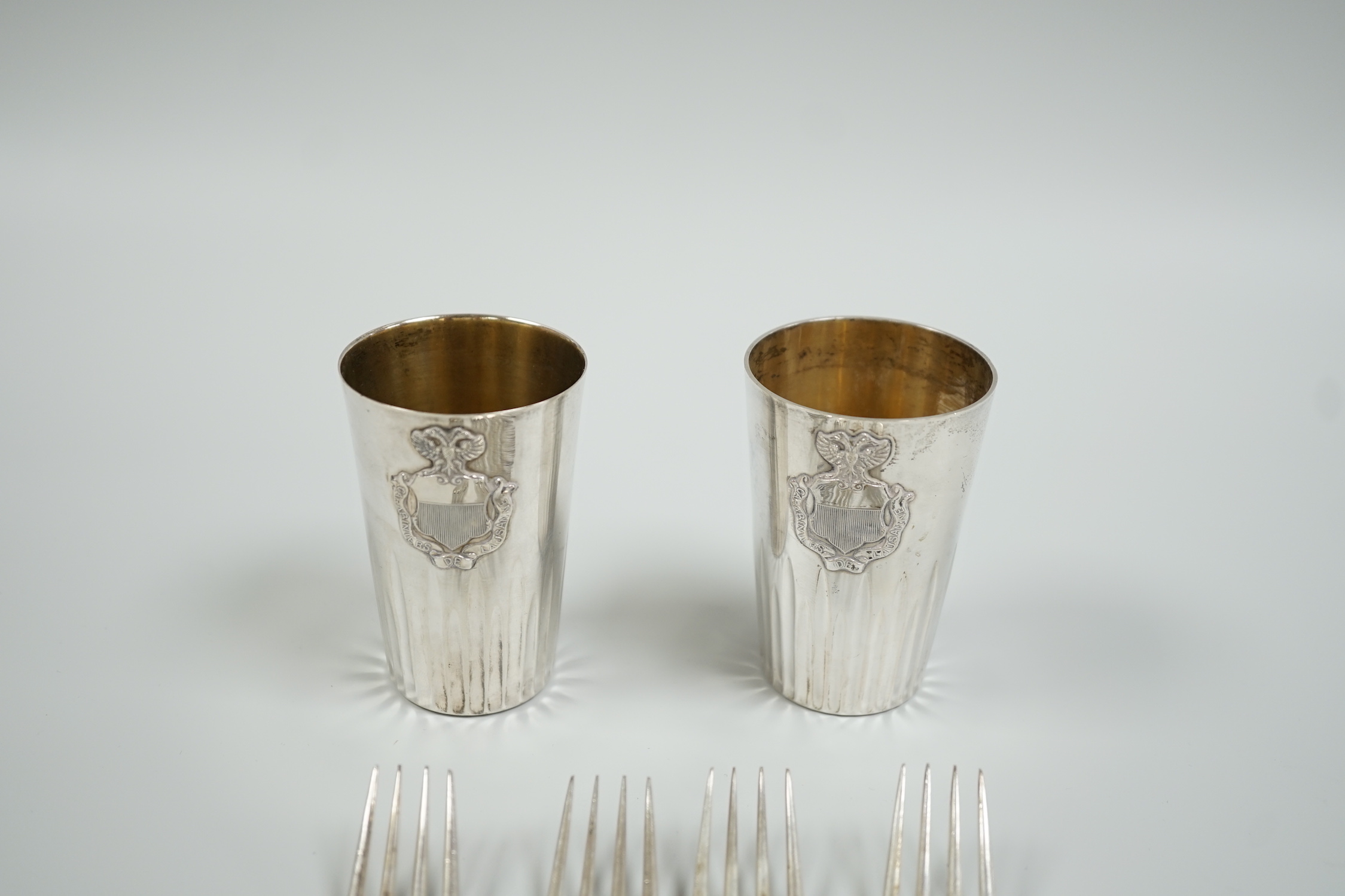 A pair of continental 800 standard white metal beakers, 75mm and four silver rat tail pattern dessert forks, Sheffield, 1929, gross weight 10.3oz.